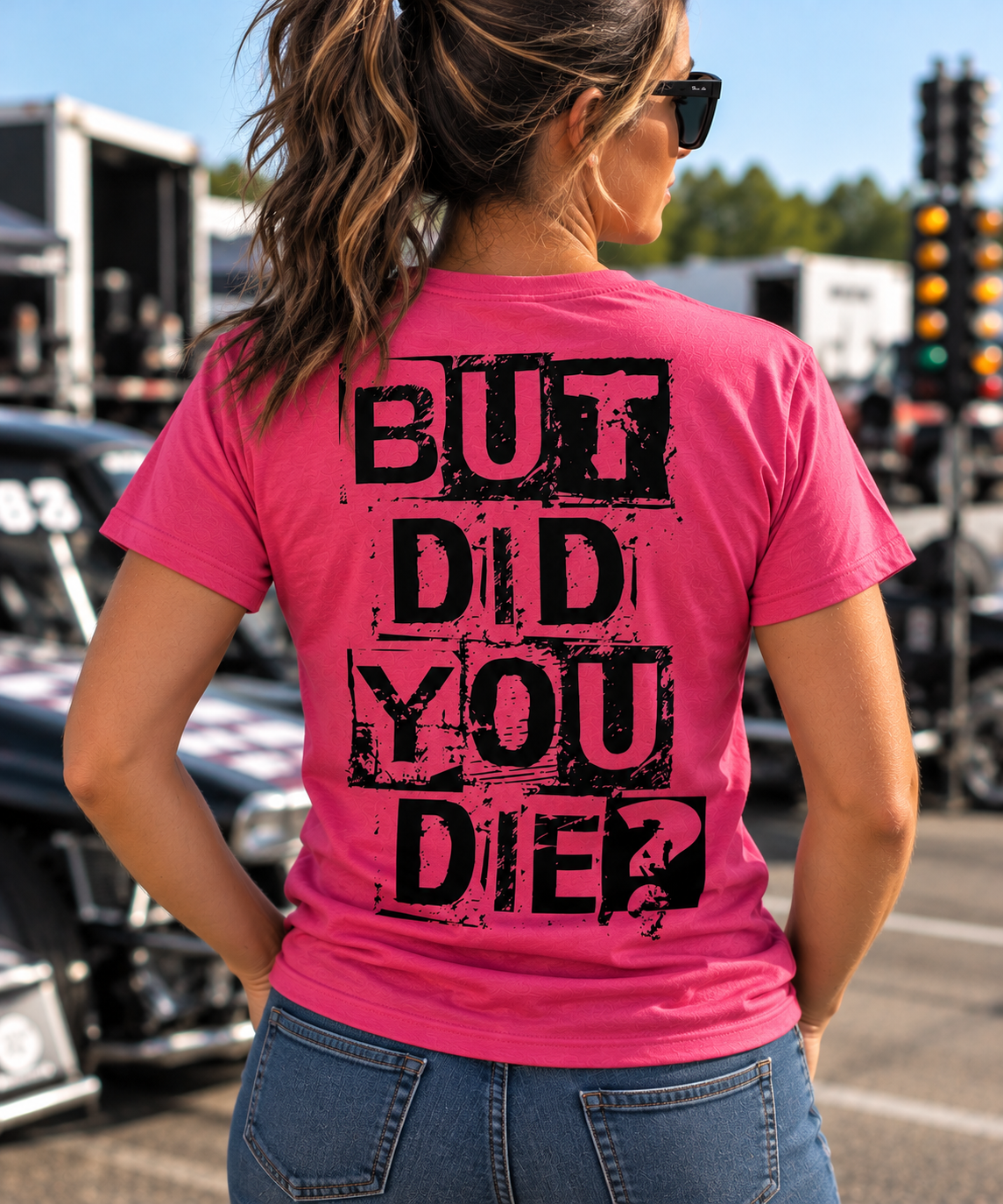 Woman wearing dark pink But Did You Die T-shirt with black distressed back graphic at a drag racing event by Car Chix