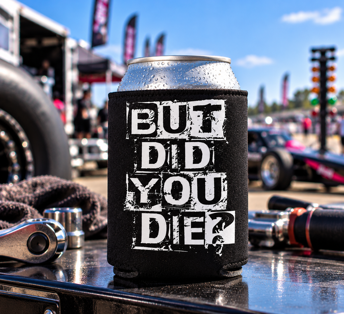 Black But Did You Die can koozie with distressed white lettering displayed on a toolbox with racing tools at a drag racing event by Car Chix