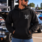 Man modeling black But Did You Die pullover hoodie, front view at a car show, by Car Chix
