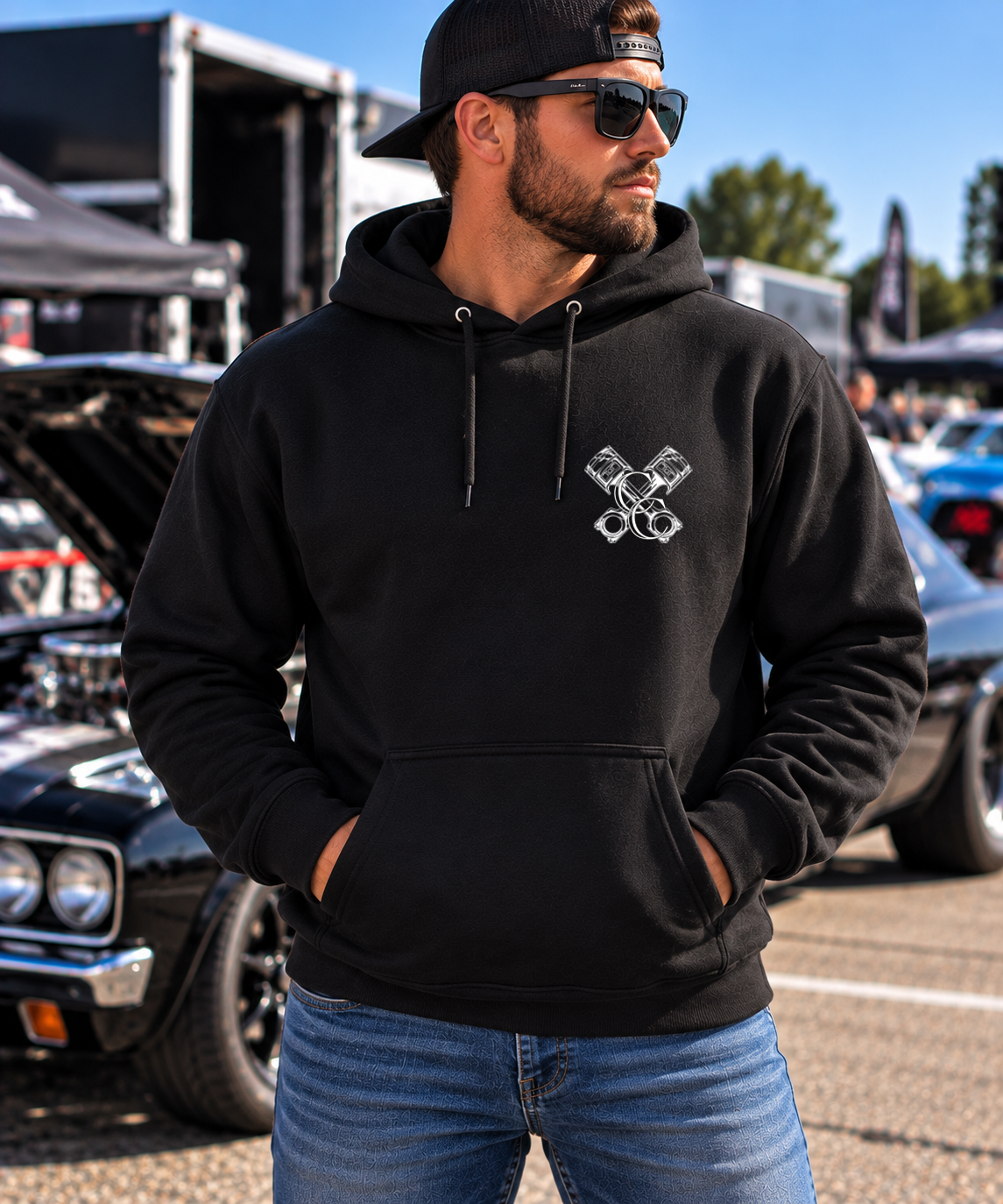 Man modeling black But Did You Die pullover hoodie, front view at a car show, by Car Chix