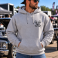 Man modeling grey But Did You Die pullover hoodie, front view at an automotive event, by Car Chix