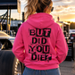Woman wearing pink But Did You Die hoodie with large black distressed back graphic at a motorsports event by Car Chix