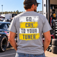 Man modeling a sport grey Car Chix Go Cry to Your Tuner T-shirt with white and yellow distressed back graphic in a motorsports pit area.