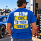 Man wearing a royal blue Go Cry to Your Tuner T-shirt by Car Chix with bold white and yellow distressed lettering at a drag racing event.