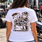 Woman with dark hair wearing white Car Chix Haze Memorial T-shirt featuring Haze tribute artwork on the back at a drag racing event