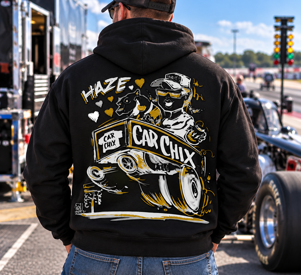 Man wearing black Car Chix Haze Memorial Hoodie featuring original Haze racing artwork on the back at a drag racing event