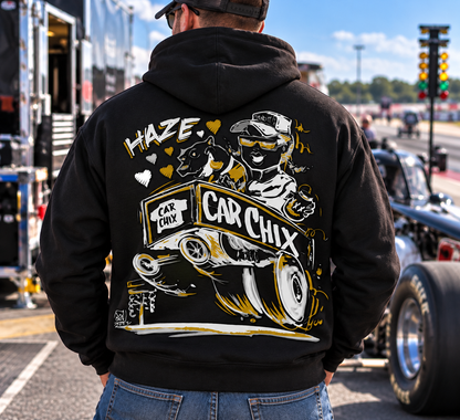 Man wearing black Car Chix Haze Memorial Hoodie featuring original Haze racing artwork on the back at a drag racing event