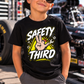 Boy wearing black Safety Third youth T-shirt at a motorsports event by Car Chix