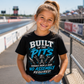 Girl wearing Built in the Pits Thanks Mom and Dad kids racing tee at a drag strip