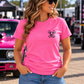 Woman wearing pink Car Chix unisex T-shirt shown from the front at an automotive event, with a blank chest area for the Car Chix Piston logo.