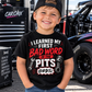 Boy wearing I Learned My First Bad Word in the Pits youth racing shirt at the racetrack