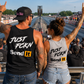 Man and woman cheering at drag strip in Just Fckn Send It racing tank tops