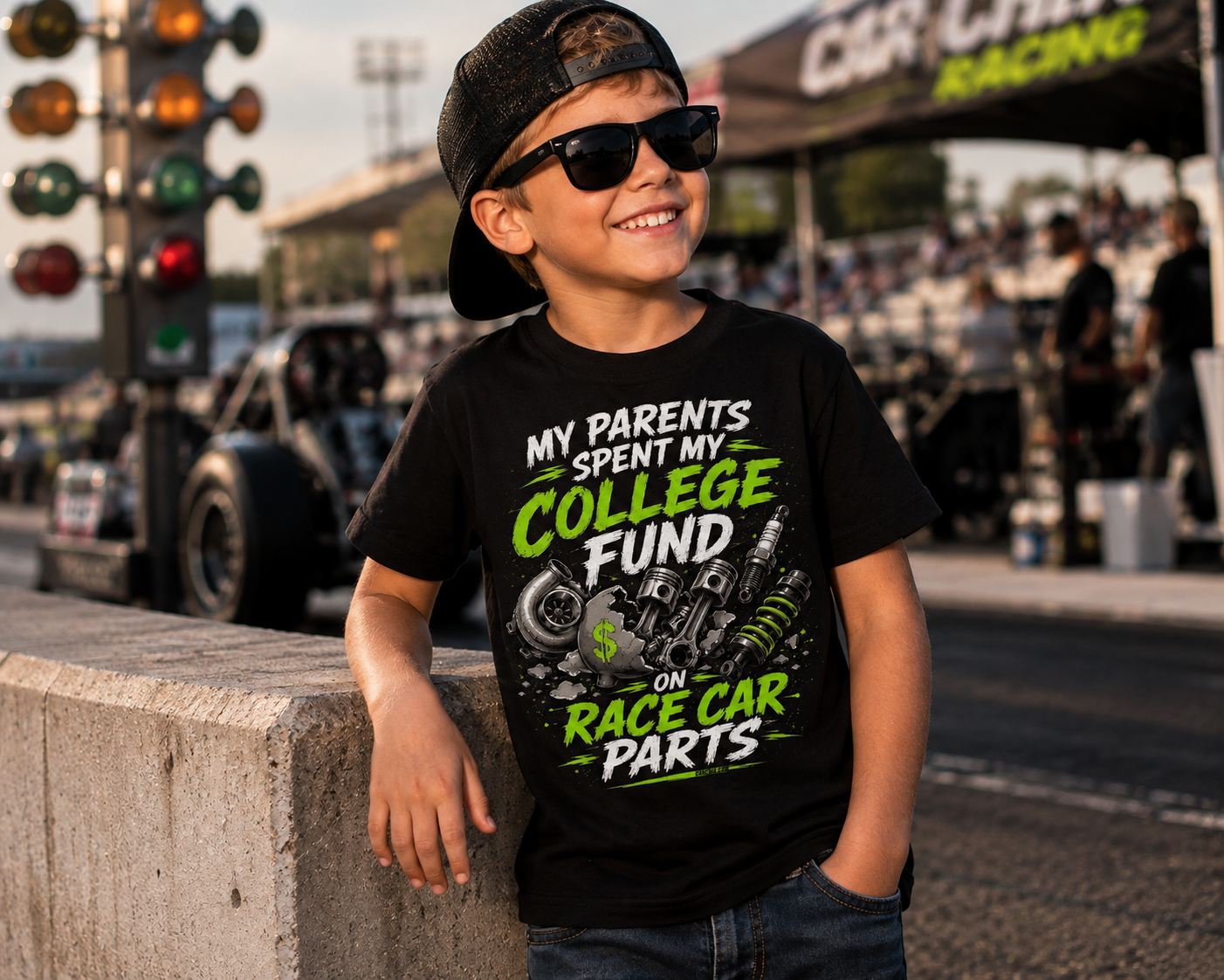 Young race fan wearing College Fund Race Car Parts kids racing tee in the pits