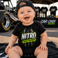 Baby wearing Nitro Cheaper Than Therapy onesie by Car Chix at the racetrack