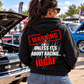 Woman wearing black Car Chix Unless It's About Racing IDGAF hoodie with bold red and white back graphic at a classic car show featuring muscle cars.