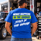 Man wearing a blue Car Chix What Happens in the Garage Stays in the Garage T-shirt featuring a neon yellow and white back print, standing beside a race car.